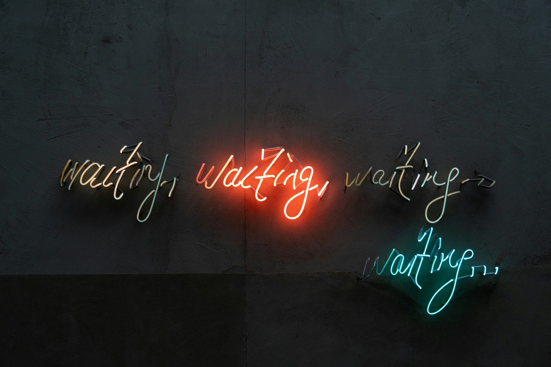 Cursive neon sign says Waiting waiting waiting waiting